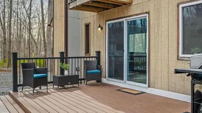 a deck with chairs and a sliding glass door at Access to Private Lake Pools Sports Complex • Fire Pit Foxden by AvantStay in East Stroudsburg