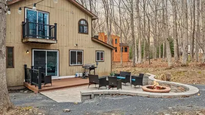 a house with a patio with a table and chairs at Access to Private Lake Pools Sports Complex • Fire Pit Foxden by AvantStay in East Stroudsburg