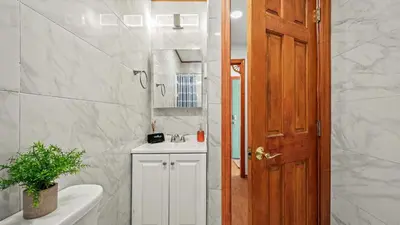 a bathroom with a sink and a toilet and a door at Access to Private Lake Pools Sports Complex • Fire Pit Foxden by AvantStay in East Stroudsburg