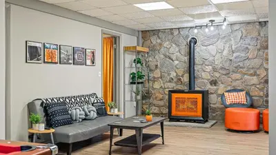 a living room with a couch and a stone wall at Emerald Bluff by AvantStay Lake Views Deck Fire Pit Game Room in Long Pond