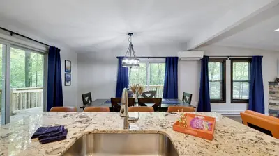 a kitchen and living room with a dining room at Moshannon Tree-Lined Pocono Retreat w Hot Tub Firepit Pool Table in Pocono Lake