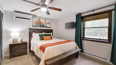 a bedroom with a bed and a ceiling fan at Moshannon Tree-Lined Pocono Retreat w Hot Tub Firepit Pool Table in Pocono Lake