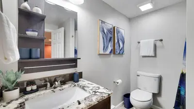 a bathroom with a sink and a toilet and a mirror at Moshannon Tree-Lined Pocono Retreat w Hot Tub Firepit Pool Table in Pocono Lake