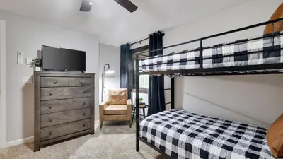 a bedroom with a bunk bed and a dresser with a tv at Moshannon Tree-Lined Pocono Retreat w Hot Tub Firepit Pool Table in Pocono Lake