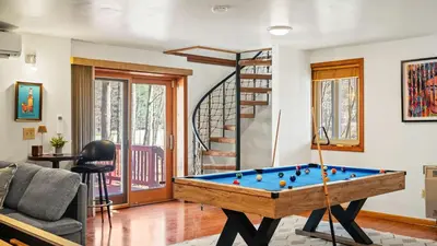 a living room with a pool table and a staircase at Pirate-Themed Lakefront Home w Kayaks Game Room Views Hidden Treasure Hunt in East Stroudsburg