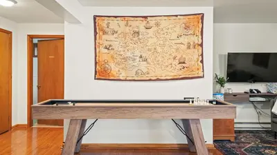 a table in a living room with a map on the wall at Pirate-Themed Lakefront Home w Kayaks Game Room Views Hidden Treasure Hunt in East Stroudsburg
