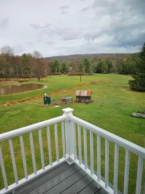 a balcony with a view of a field and a park at Charming Twin Ponds Estate On 27 Acres in Woodbourne