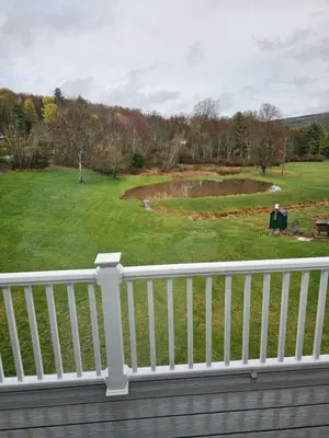 a white rail on a porch with a view of a park at Charming Twin Ponds Estate On 27 Acres in Woodbourne