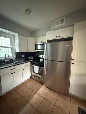 a kitchen with white cabinets and a stainless steel refrigerator at MetLife 10 Min 8 Guests Free Parking in Jersey City