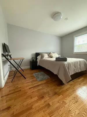 a bedroom with a bed and a wooden floor at MetLife 10 Min 8 Guests Free Parking in Jersey City