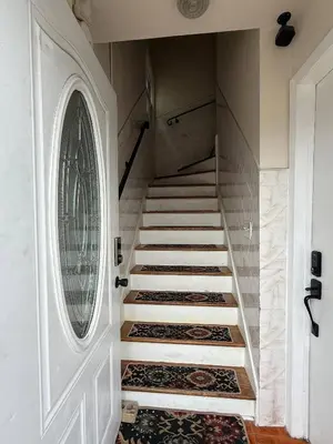 a staircase with a round window and a white door at MetLife 10 Min 8 Guests Free Parking in Jersey City