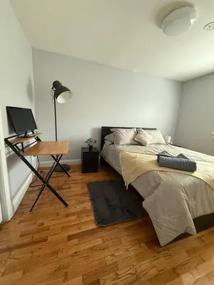 a bedroom with a bed and a desk with a laptop at MetLife 10 Min 8 Guests Free Parking in Jersey City