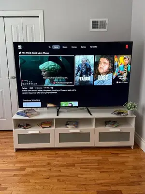 a flat screen tv sitting on top of a white entertainment center at MetLife 10 Min 8 Guests Free Parking in Jersey City