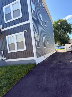 a house with a driveway next to a building at E&G homes in East Orange