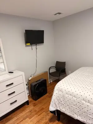 a bedroom with a bed and a tv on the wall at E&G homes in East Orange