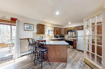 a kitchen with a island with bar stools at Burntwood Retreat in East Stroudsburg