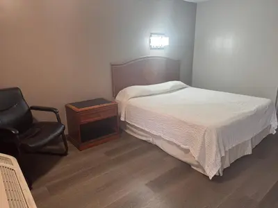 a small bedroom with a bed and a chair at Farrington Inn - North Brunswick in North Brunswick