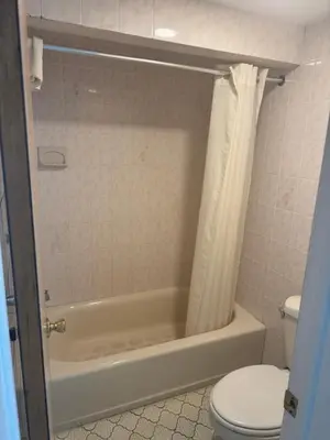 a bathroom with a tub and a toilet and a shower at Farrington Inn - North Brunswick in North Brunswick