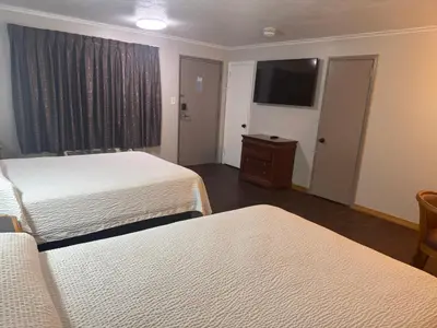 a hotel room with two beds and a flat screen tv at Farrington Inn - North Brunswick in North Brunswick