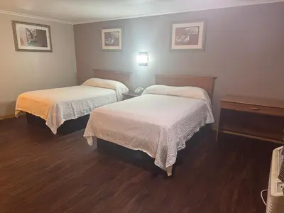 a hotel room with two beds and a table at Farrington Inn - North Brunswick in North Brunswick