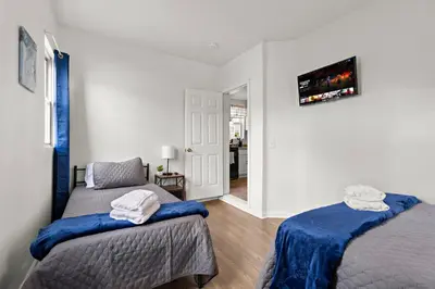 a bedroom with two beds and a hallway at Fun Family getaway - NYC & NWK w free parking in Newark