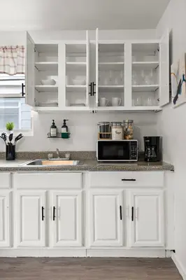 a kitchen with white cabinets and a microwave at Fun Family getaway - NYC & NWK w free parking in Newark