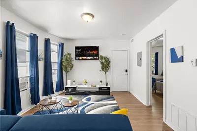 a living room with a blue couch and blue curtains at Fun Family getaway - NYC & NWK w free parking in Newark
