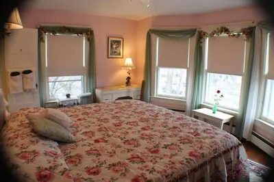 a bedroom with a large bed with a floral bedspread at The White Birch Inn in Berwick