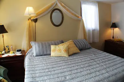 a bedroom with a bed with a blue comforter at The White Birch Inn in Berwick