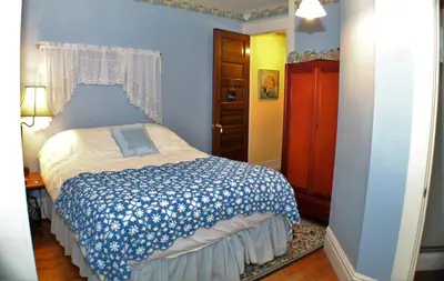 a bedroom with a bed with a blue wall at The White Birch Inn in Berwick
