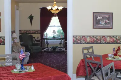 a living room with a table and a dining room at The White Birch Inn in Berwick