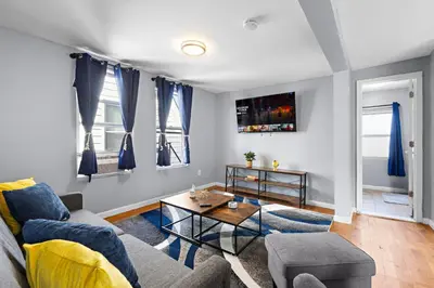 a living room with a couch and a table at Peaceful Hideaway - NYC & NWK with free parking in Newark