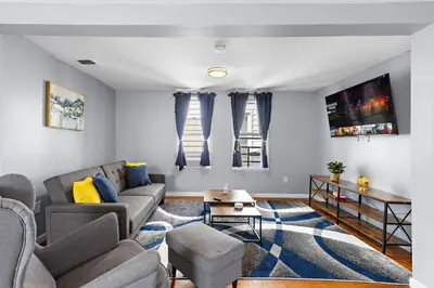 a living room with a couch and a table at Peaceful Hideaway - NYC & NWK with free parking in Newark