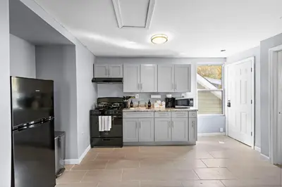 a kitchen with white cabinets and a black stove at Peaceful Hideaway - NYC & NWK with free parking in Newark