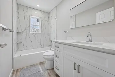 a white bathroom with a sink toilet and a mirror at Renovated 6 bed Hot Tub Sauna Firepit & Beach in Lake Harmony