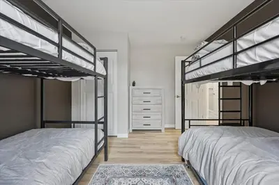 a bedroom with two bunk beds and a dresser at Renovated 6 bed Hot Tub Sauna Firepit & Beach in Lake Harmony