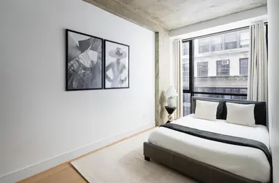 a white bedroom with a bed and a window at Stunning Apartment in Manhattan with Patio in New York