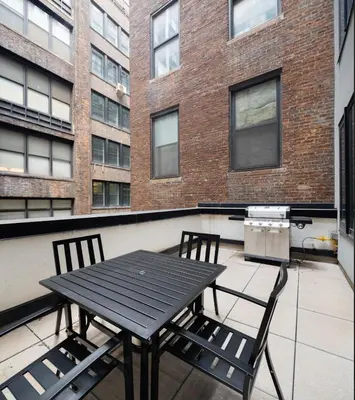 a black table and two chairs on a balcony at Stunning Apartment in Manhattan with Patio in New York