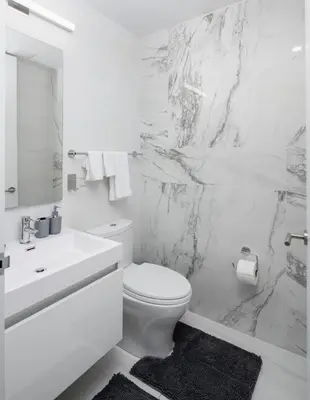 a white bathroom with a toilet and a sink at Stunning Apartment in Manhattan with Patio in New York