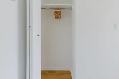 a sliding door leading into a room with a closet at Blueground Battery Park City rooftop nr Hudson River NYC-291 in New York