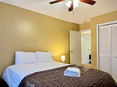 a bedroom with a bed with a ceiling fan at Huge Place Minutes from NYC Parking Available in Guttenberg