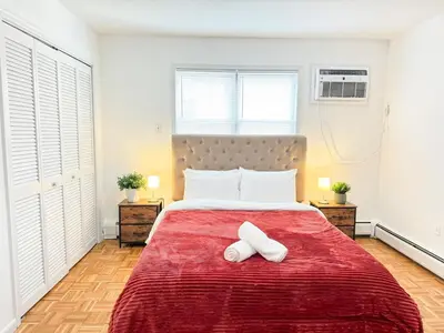 a bedroom with a red bed with two towels on it at Spacious and Convinient near NYC Parking Available in Guttenberg