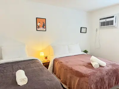 a bedroom with two beds and a air conditioner at Spacious and Convinient near NYC Parking Available in Guttenberg