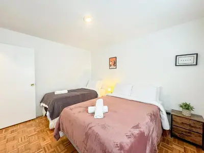 a bedroom with two beds with a cross on the bed at Spacious and Convinient near NYC Parking Available in Guttenberg