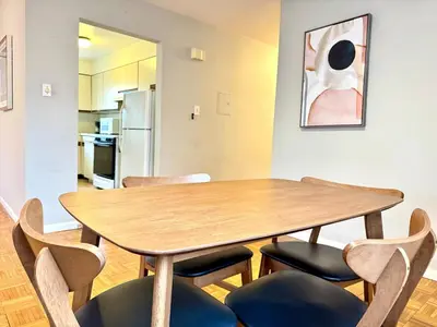 a dining room with a wooden table and chairs at Spacious and Convinient near NYC Parking Available in Guttenberg