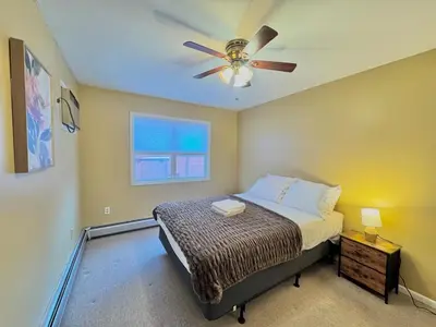 a bedroom with a bed and a ceiling fan at Spacious and Convinient near NYC Parking Available in Guttenberg