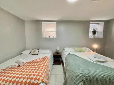 a bedroom with two beds and two windows at FREE Parking Cozy 2 Bedroom unit near NYC in North Bergen