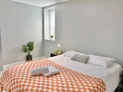 a bedroom with a bed with a orange and white blanket at FREE Parking Cozy 2 Bedroom unit near NYC in North Bergen