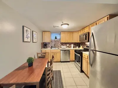 a kitchen with a wooden table and a refrigerator at FREE Parking Cozy 2 Bedroom unit near NYC in North Bergen