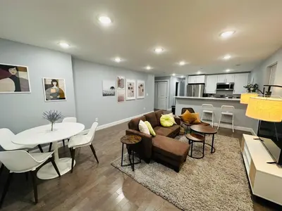 a living room with a couch and a table at 15% OFF | EWR| NYC | Metropolis Serenity Haven in Newark